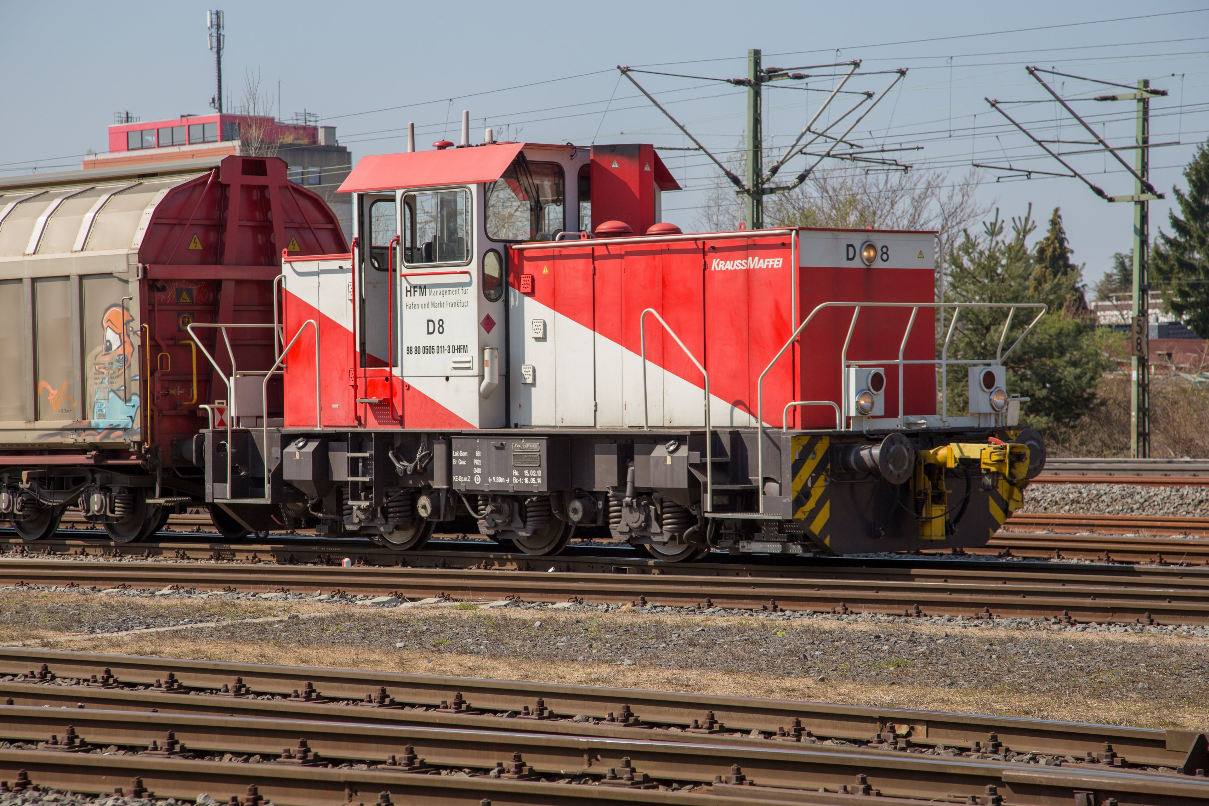 Eine rot-weiße Lokomotive auf einem Bahngleis.